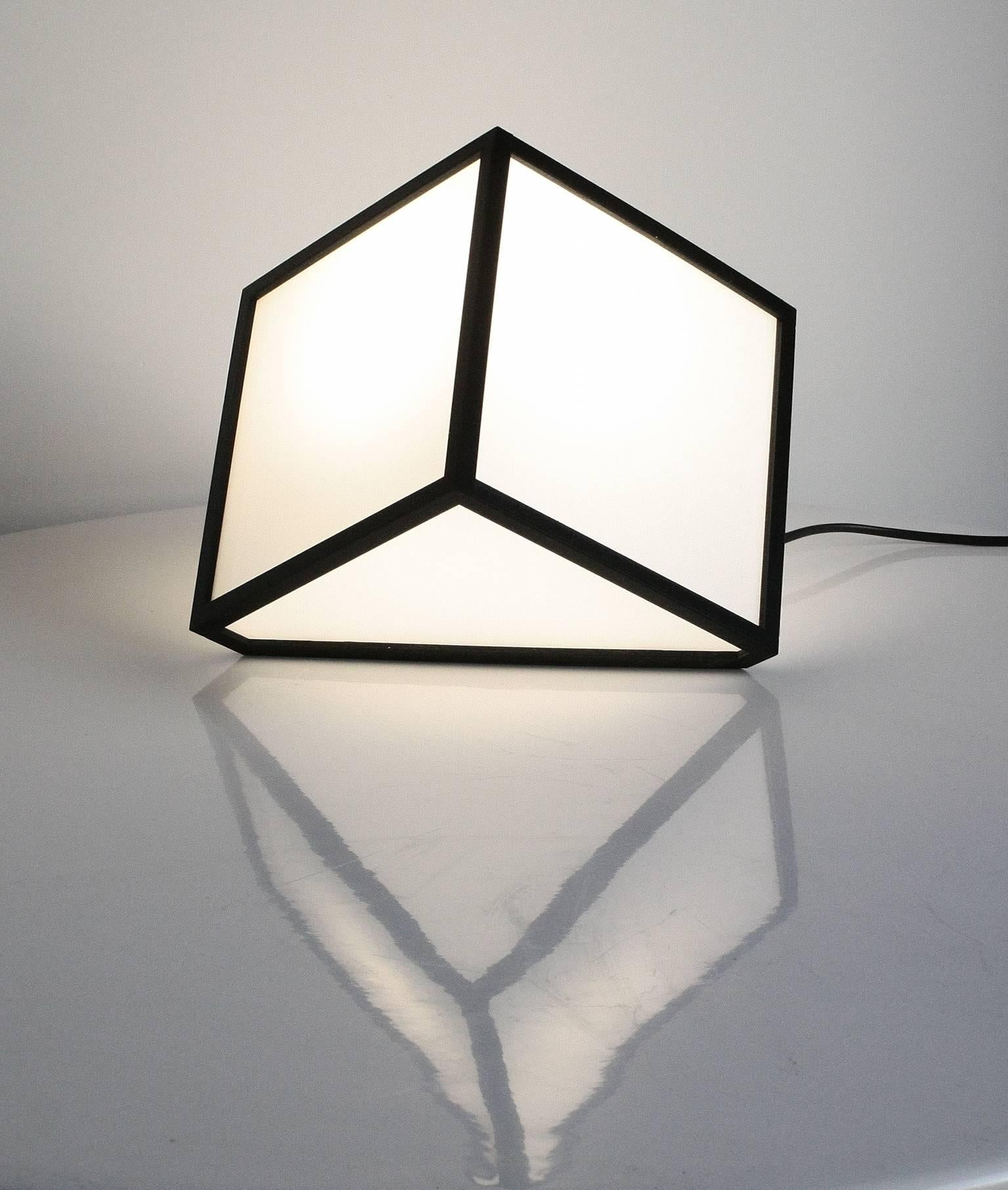 7face cube sculpture lamps are made using 3D printing and opaline plexiglass. Their main characteristic resides in the seventh face, that support, which has a different inclination depending on the model.
The black frame, made of PLA (polylactic