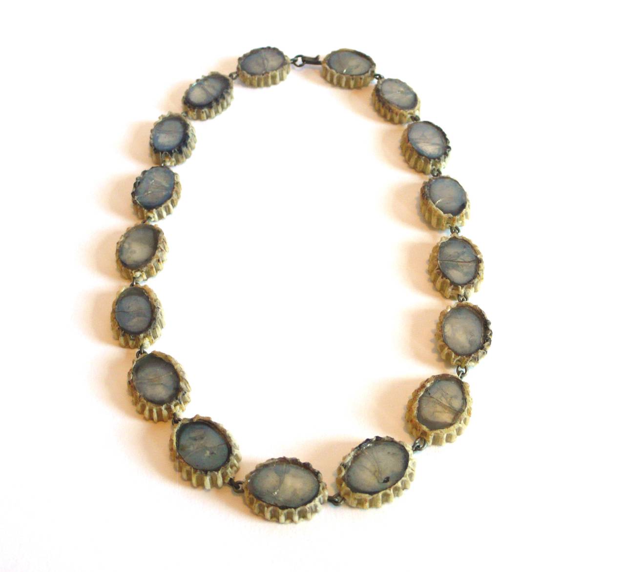 Line Vautrin Talosel necklace encrusted with olive colored mirrored glass.

Sits on neck as a choker. Model Paola.