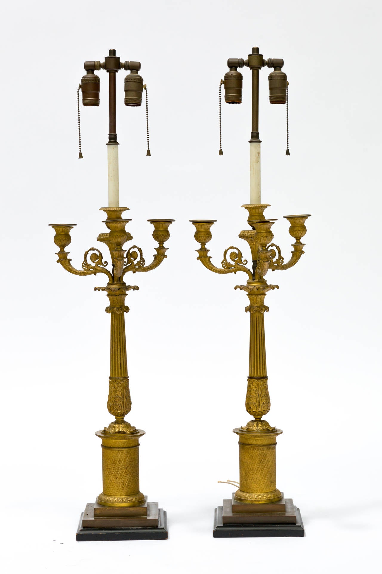 Pair of French Empire candelabrum converted to lamps, circa 1870. Beautiful detailed casting on a bronze base. Lamps have been professionally rewired.
