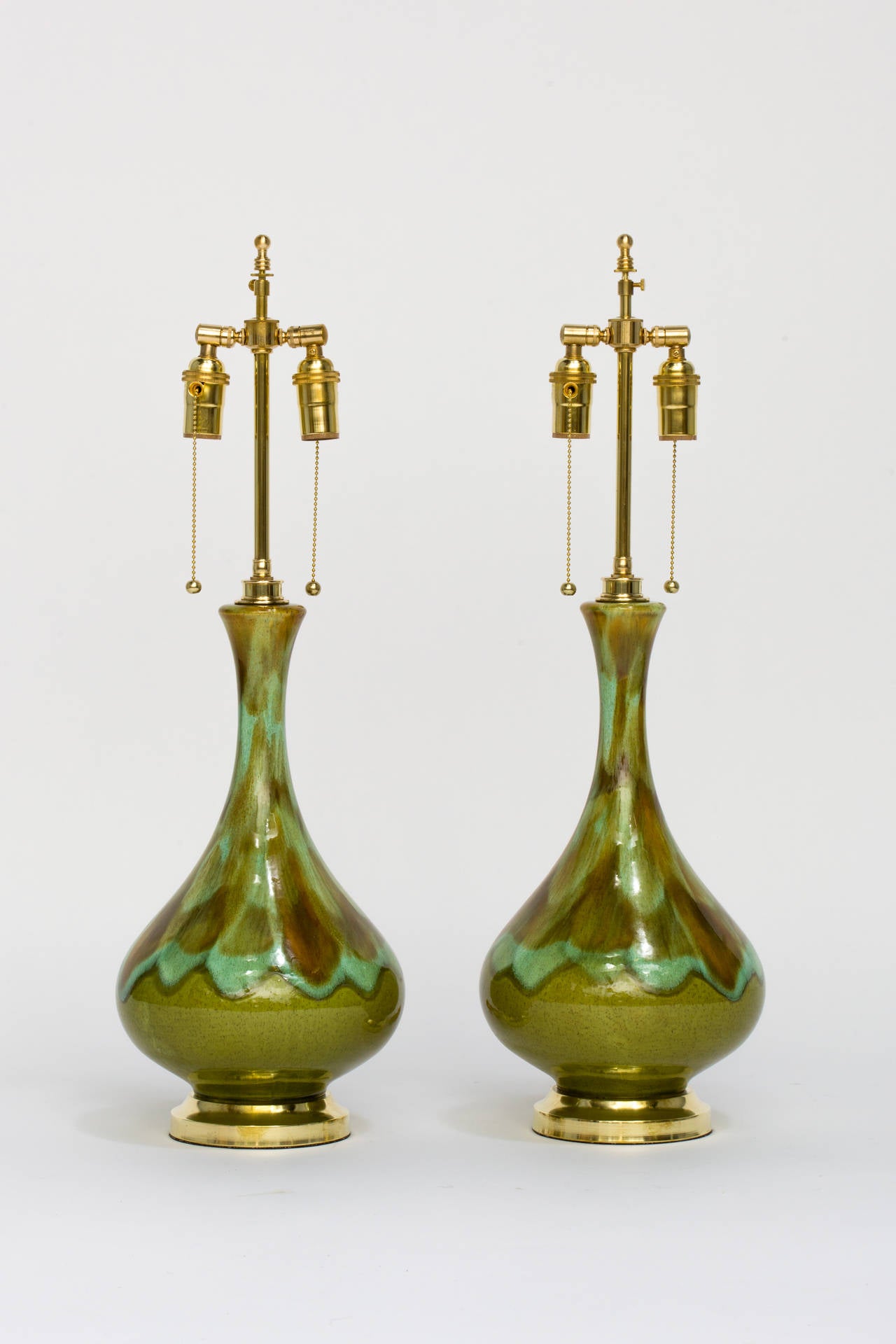 Green glazed ceramic lamps with solid brass hardware. Restored and rewired.
