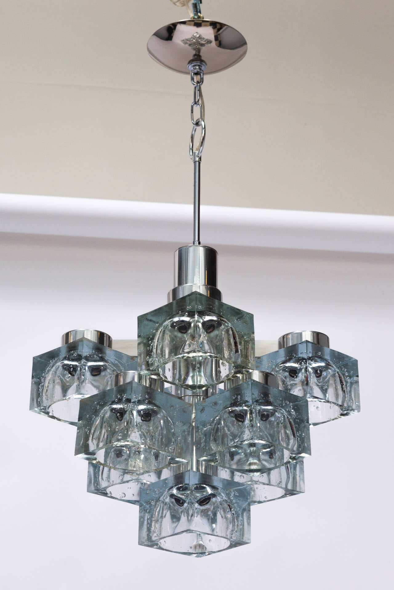 A Lightolier chandelier by Italian designer Gaetano Sciolari.
It features nine glass shades resembling ice cubes with polished nickel body. It is in excellent vintage condition, circa 1970s.