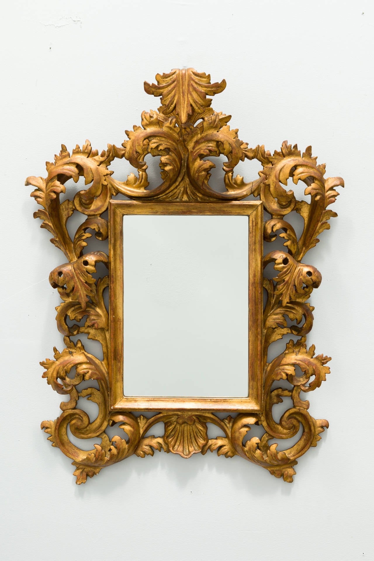 Arched wood frame, carved with scrolls and foliage.