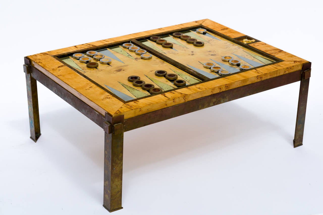 Burled wood backgammon board, sits in brass base. Includes glass top, 31 game pieces, dice and leather dice cup.