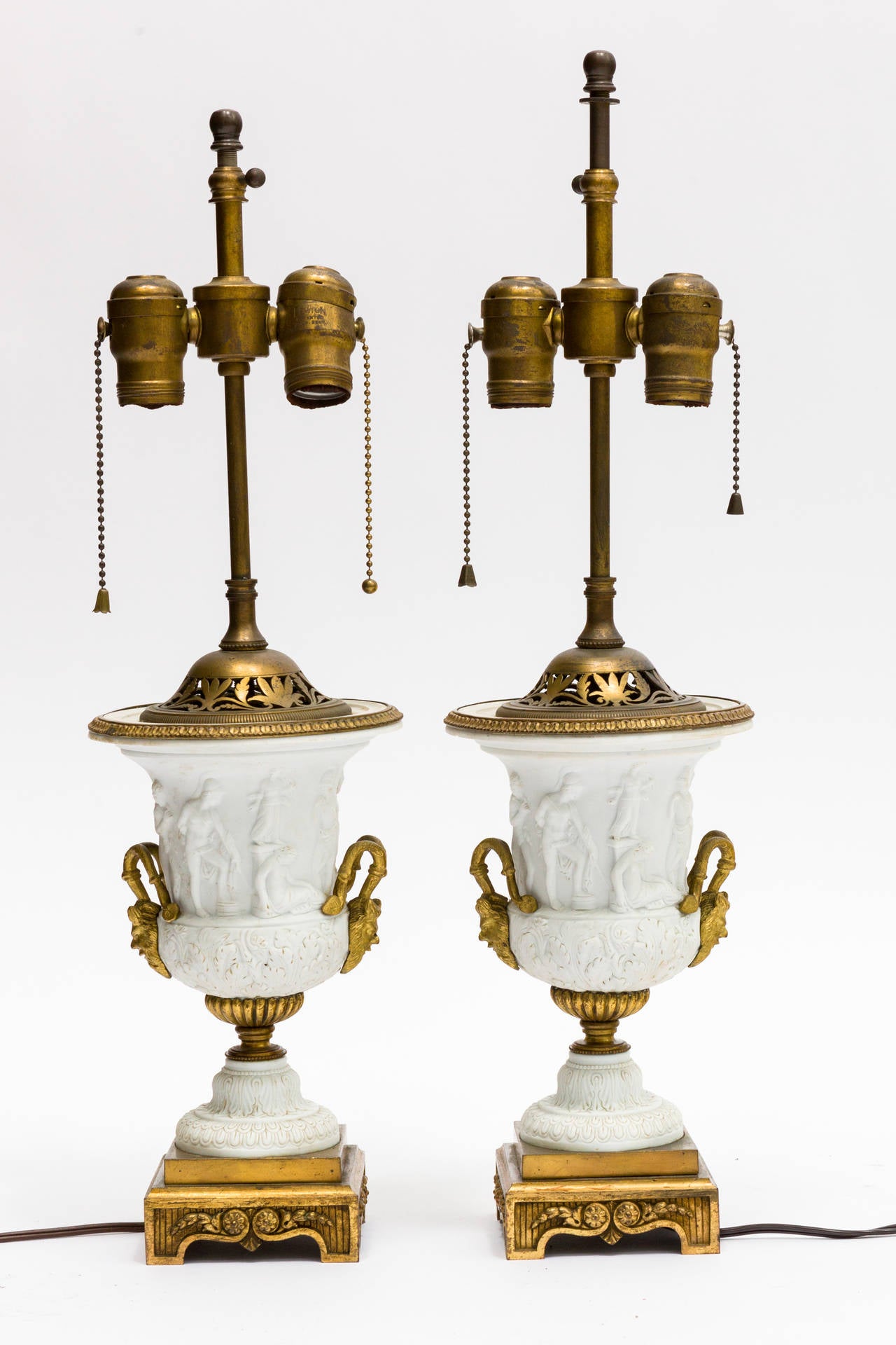 Pair of neoclassical urn lamps with bronze head handles.

Height is 18.25 from bottom of base to top of socket.