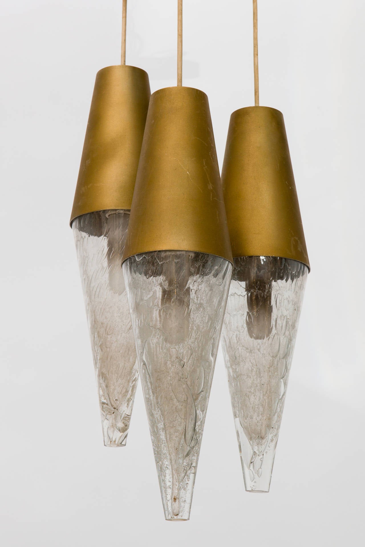 Three pendant staggered glass and metal cone, 1950s fixture.