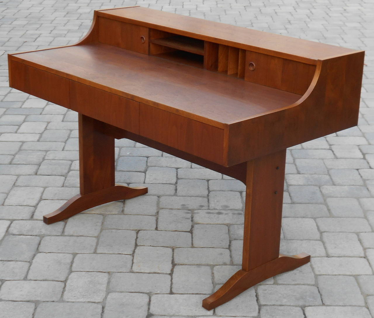 A 1970's Danish style teak writing desk. Three drawers for storage and a top section with sliding doors.
