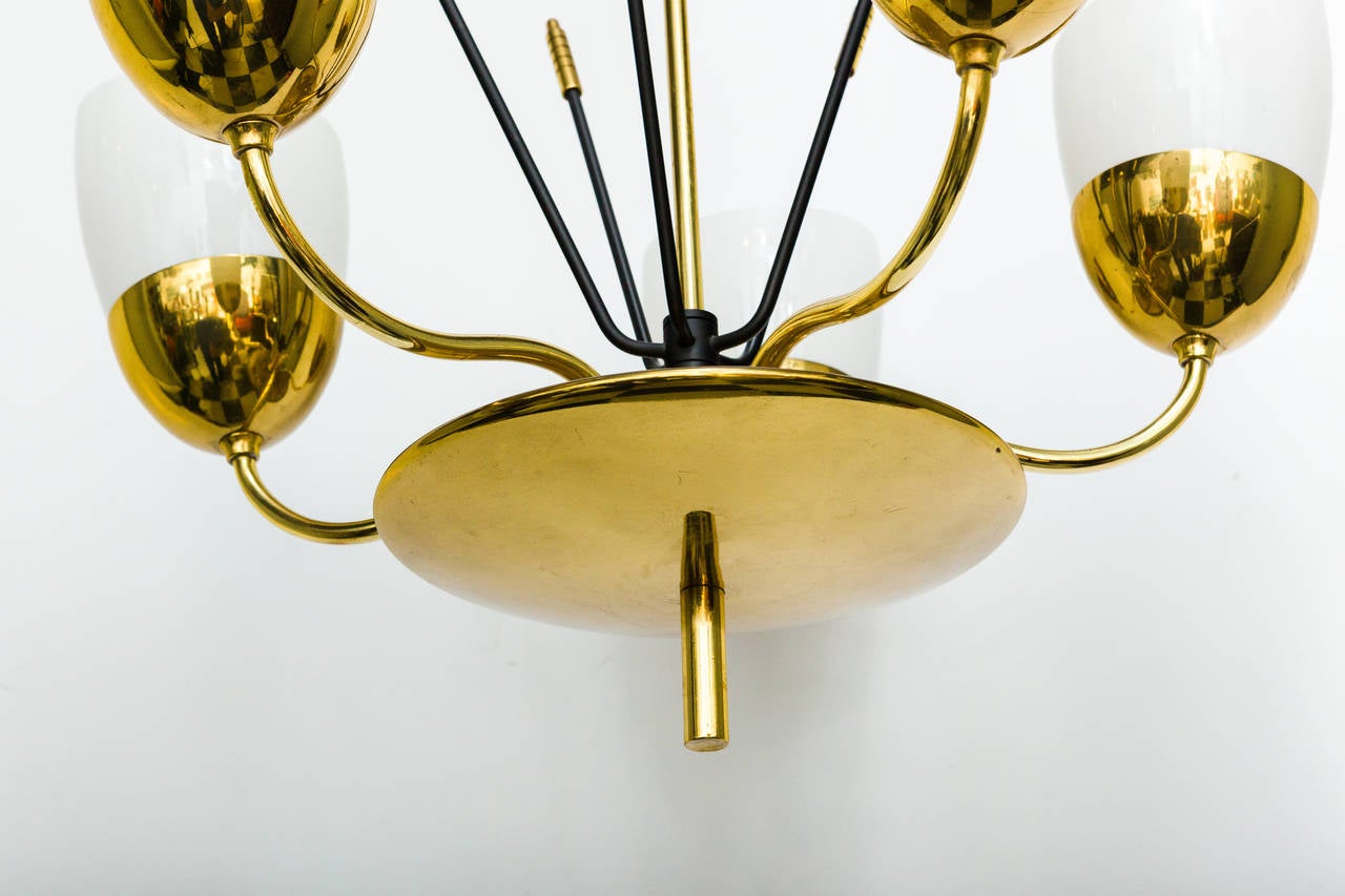 An elegant solid brass and milky glass five-arm chandelier in the manner of Paavo Tynell.