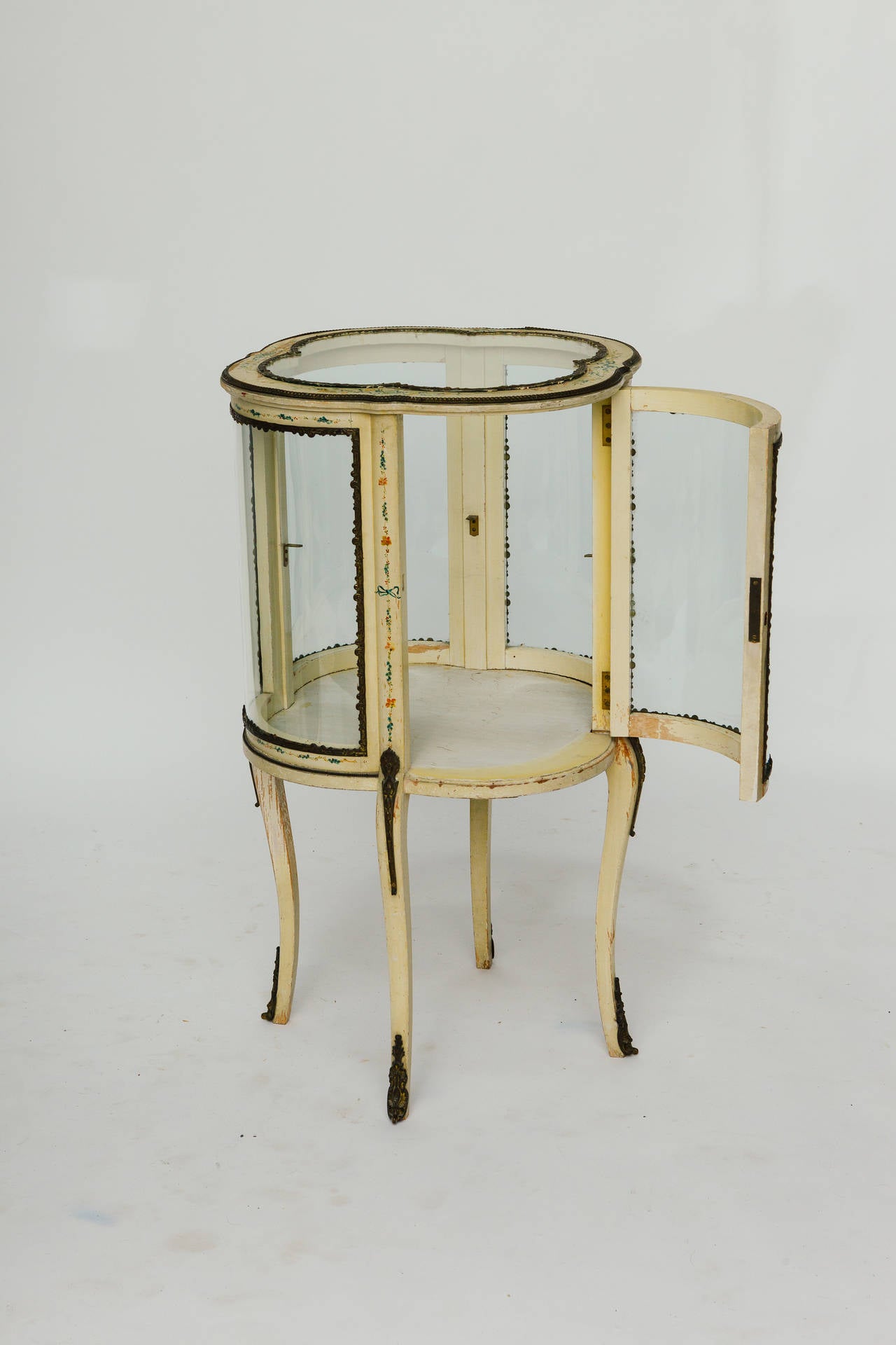 1920s painted vitrine with brass molding. One piece of molding is missing and there is no glass shelf.