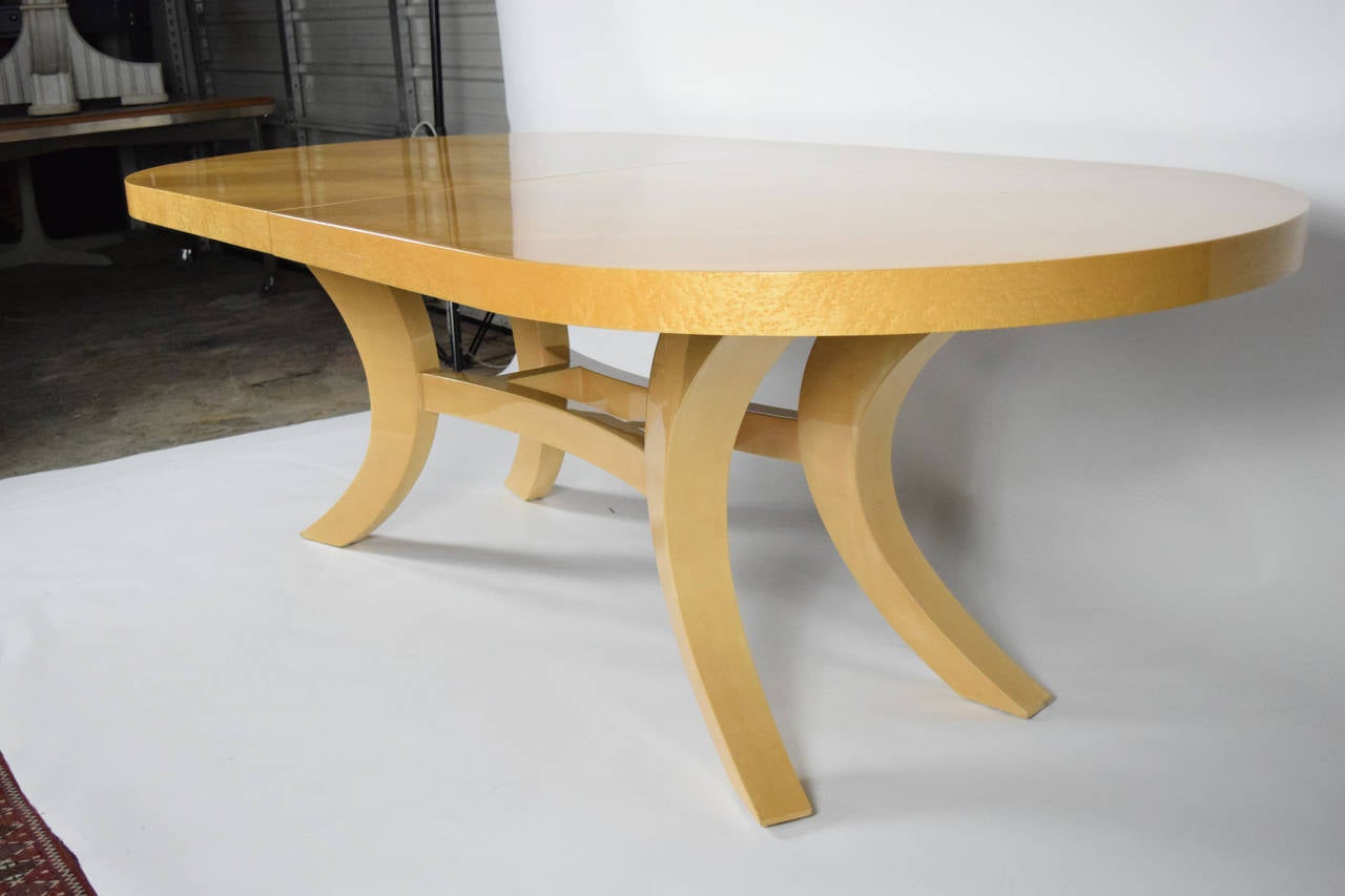 This is a gorgeous dining table by Dakota Jackson. It is birds eye maple with a striated veneer pattern and a glossy lacquer finish. The table has a 24