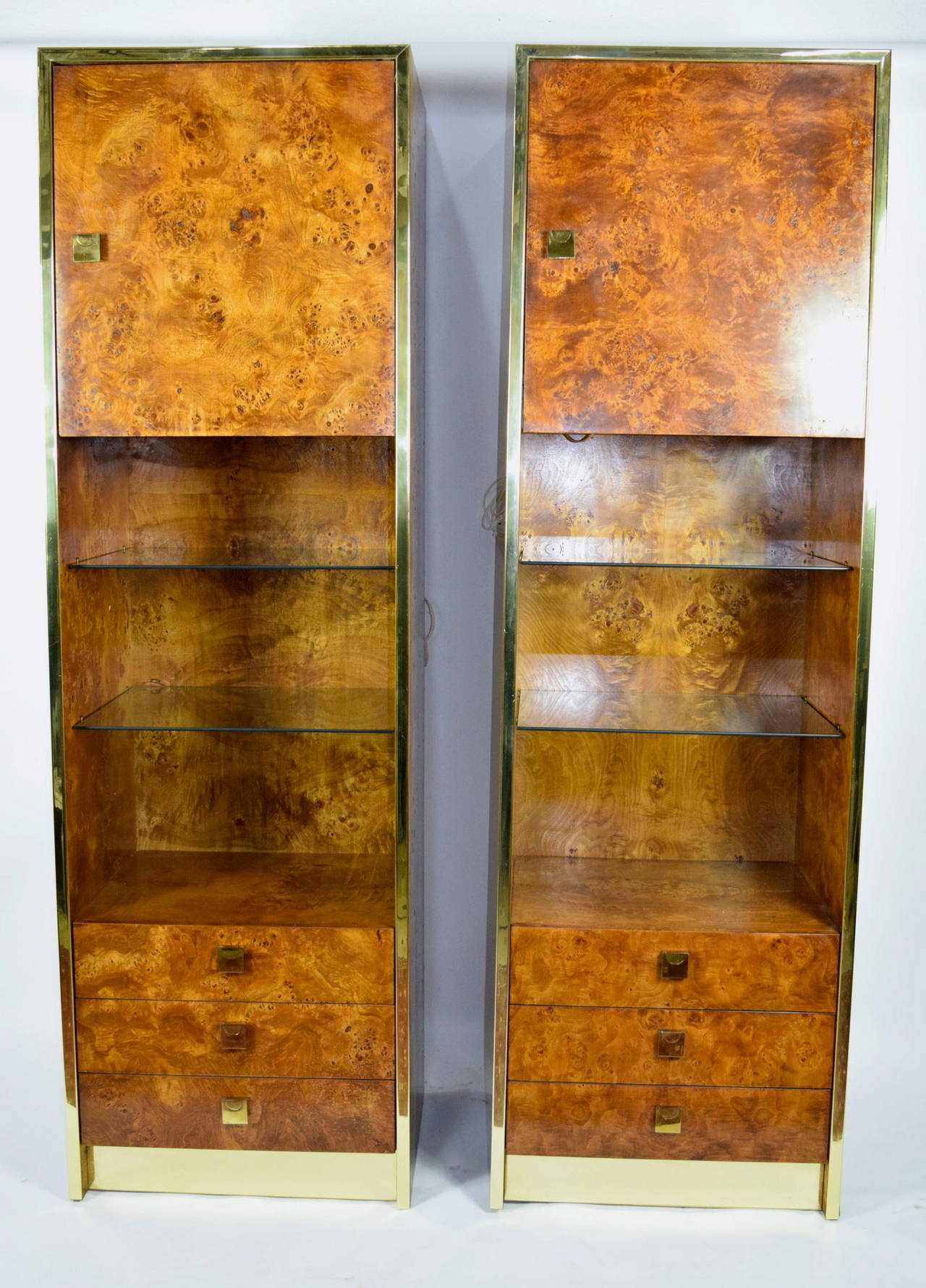 This is a gorgeous pair of Milo Baughman styled burled walnut shelf units by Founders (a division of Thomasville). They can be separate or displayed together as a single unit. There is plenty of storage, glass display shelving and drawers as well as
