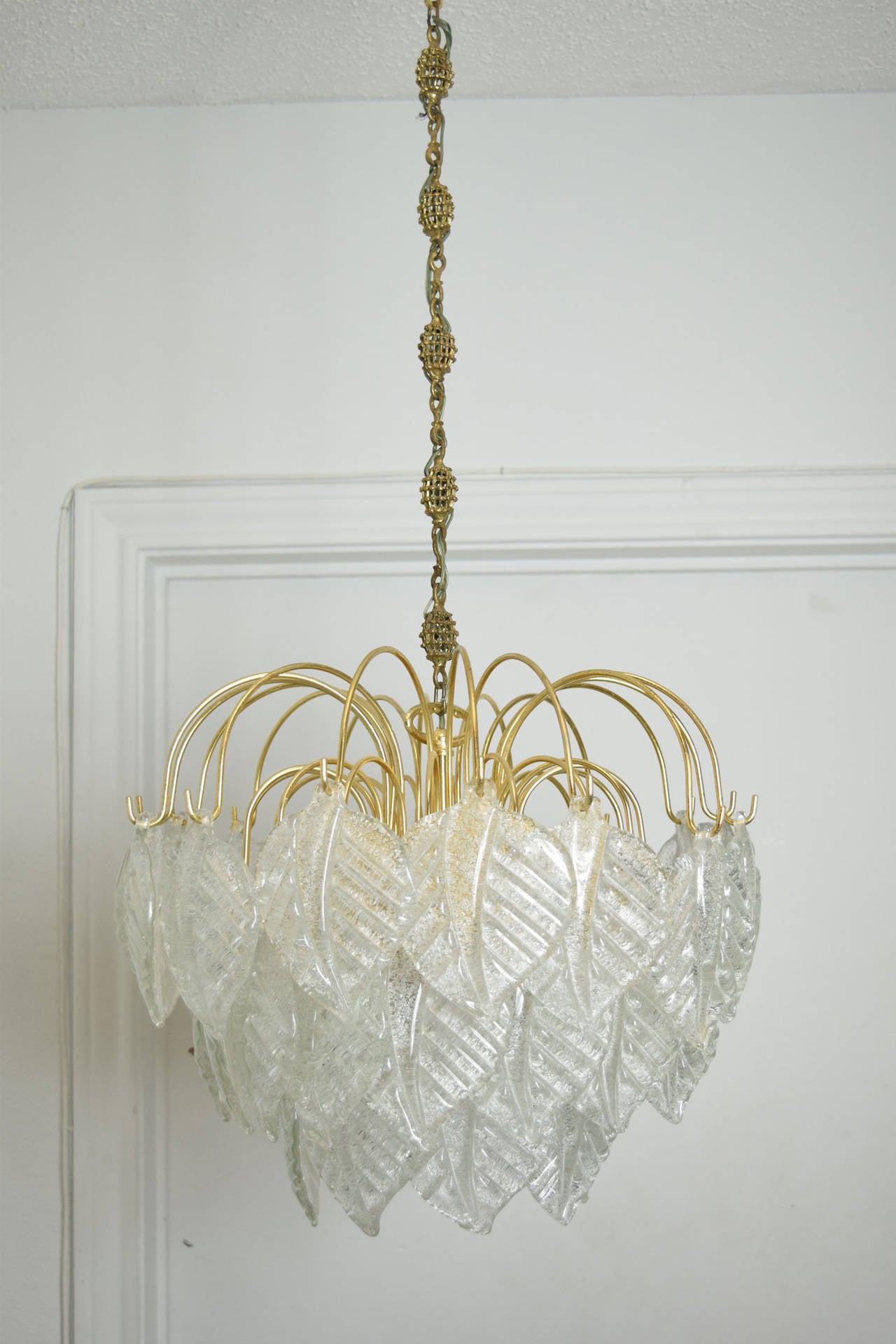 Beautiful Barovier & Toso murano glass chandelier. 40 clear glass with gold fleck petals on brass finish cage. Beautiful chain.