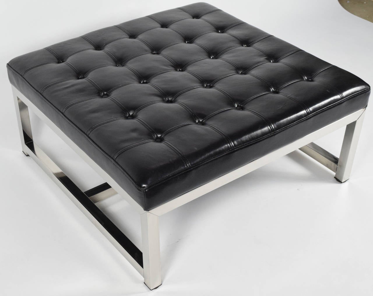 Beautiful black leather ottoman/bench in the style of Milo Baughman. Baseball stitching in grid pattern. Chrome base.