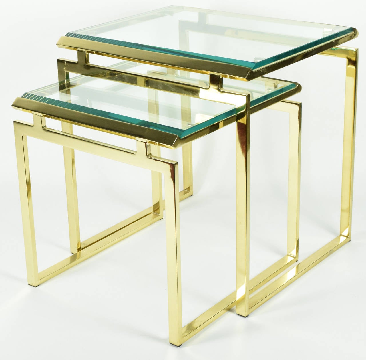 A very nice pair of elegant and simple brass finish nesting tables with beveled glass tops.  Mastercraft style. 