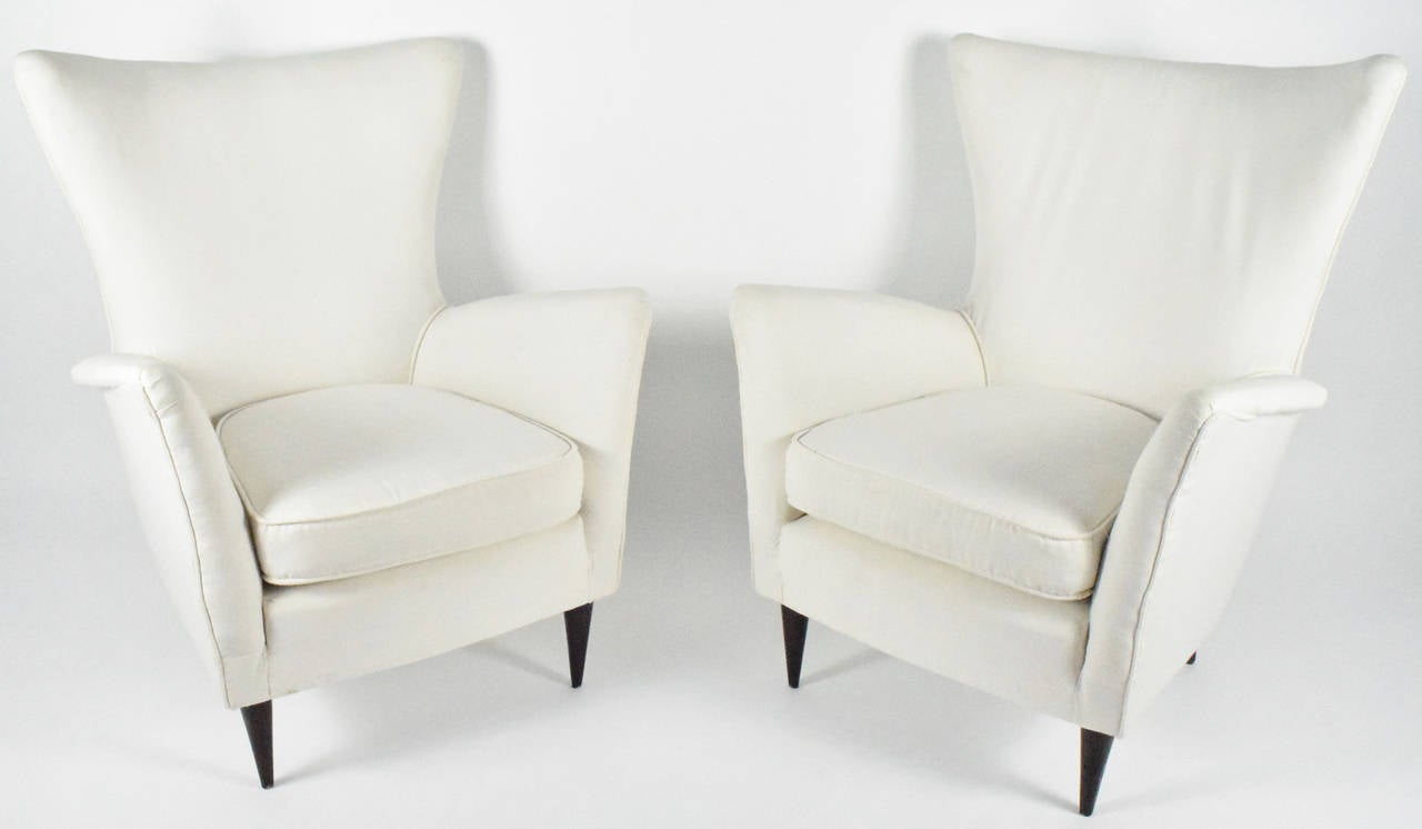 This is a very nice pair of Italian modern lounge chairs with wood mid-century modern legs. Chairs are upholstered in muslin ready for new upholstery.
