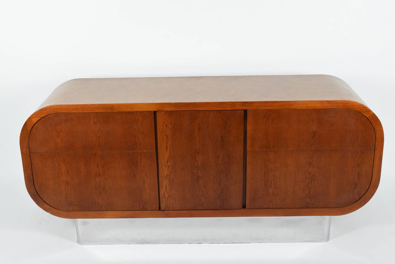 This is a beautiful credenza in oak with a leather skin and chrome base.