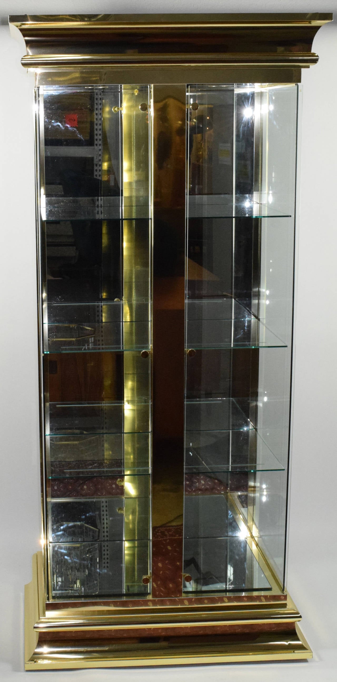 This is a beautiful lighted display cabinet with glass doors and shelves and brass finish by Mastercraft. Doors open from outside edges.