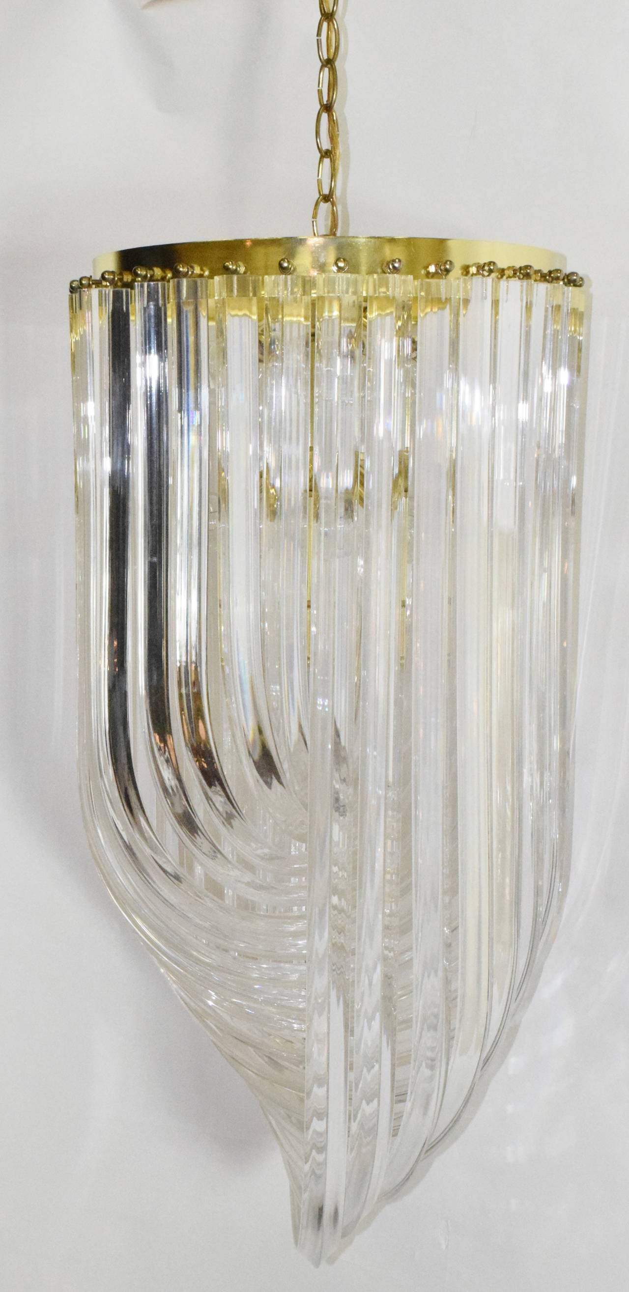 This is a beautiful tall chandelier with brass finished stem and graduating lucite bands. Includes sockets for 12 bulbs. 1960s