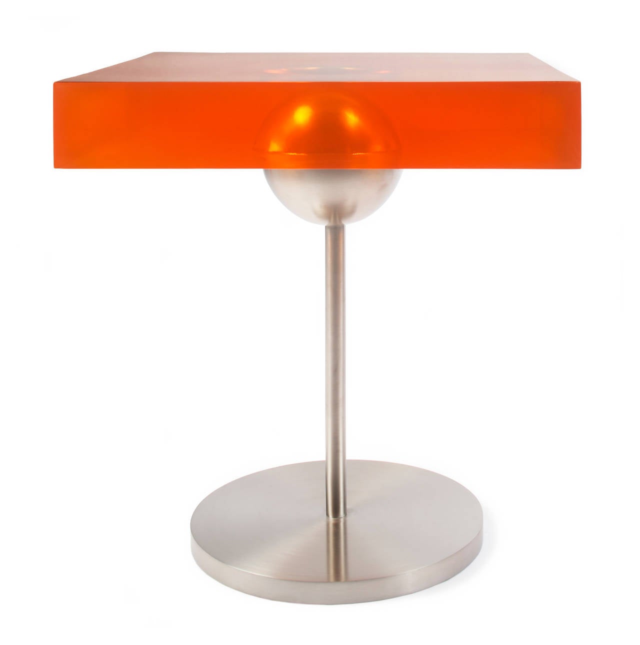 A stainless steel ball is embedded within a 31/2" thick transparent tangerine resin tabletop. Available in other colors. Each angle surprises with its myriad optical illusions created by the light bouncing off the ball within the liquid texture