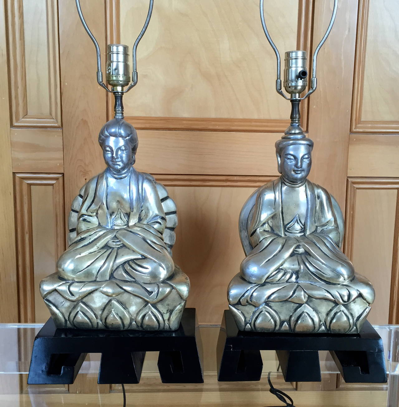 These 1950s stylized lamps of a Chinese man and woman wearing ceremonial robes, are in the style of the great James Mont. Elegantly realized, they also have endearing countenances and are finely detailed. Cast of silvered metal, they sit on the