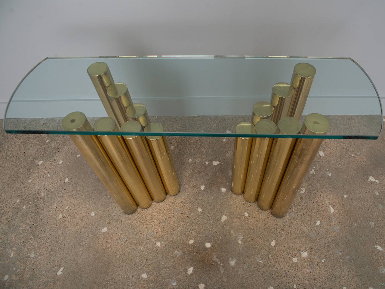 Tubular brass plated stacking console - an unusual statement piece with a thick curved glass top.