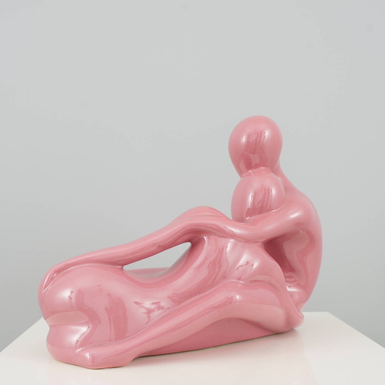 Very cool art deco statue made by Jaru circa 1983. Depicts a male and female nude couple in a loving embrace. The finish is high gloss ceramic in a bubble gum pink tone.
