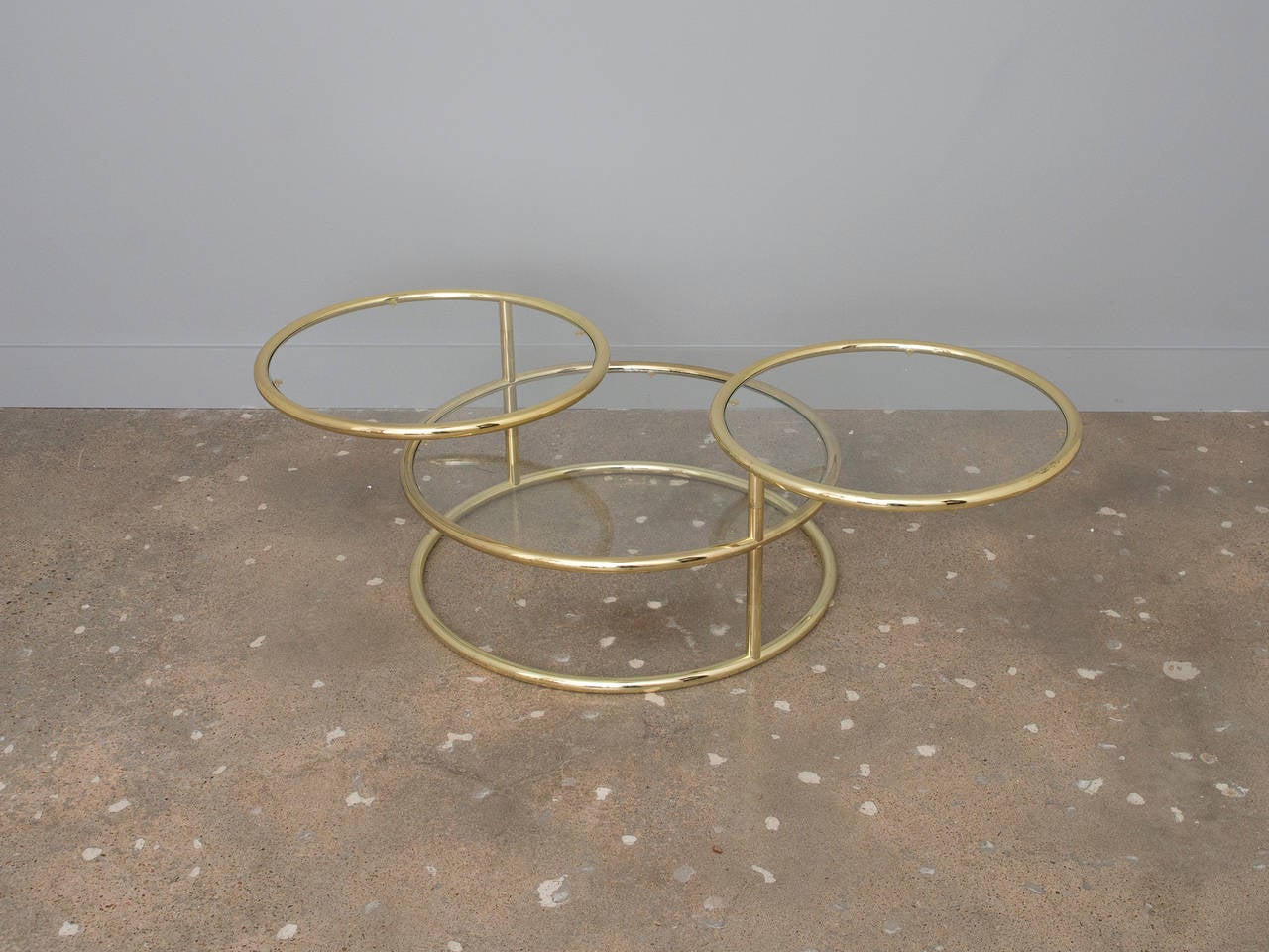 A vintage Milo Baughman style three-tier brass and glass coffee table or cocktail table.