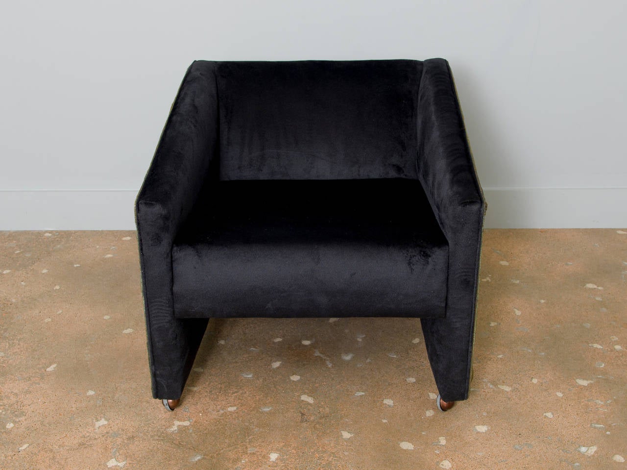 A masterful Brutalist chair (on wheels) encased with stamped resin on three sides. We have the matching loveseat and sofa on a separate listing. The brutalist pieces are covered in a black faux fur that is almost a velvet material.  The fabric is