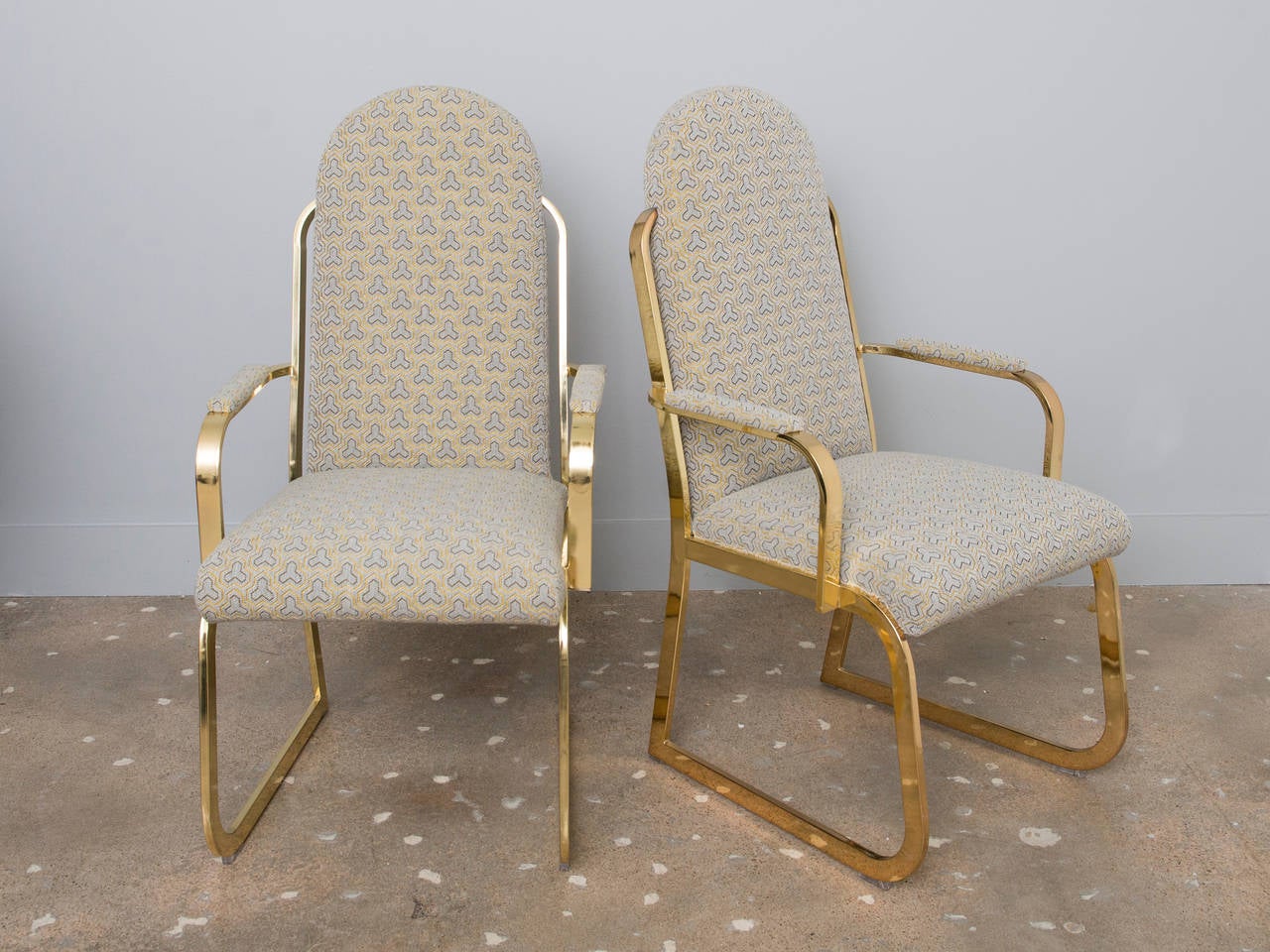 Beautiful rounded brass plated dining chairs in the style of Milo Baughman, recently recovered in David Hicks style fabric.