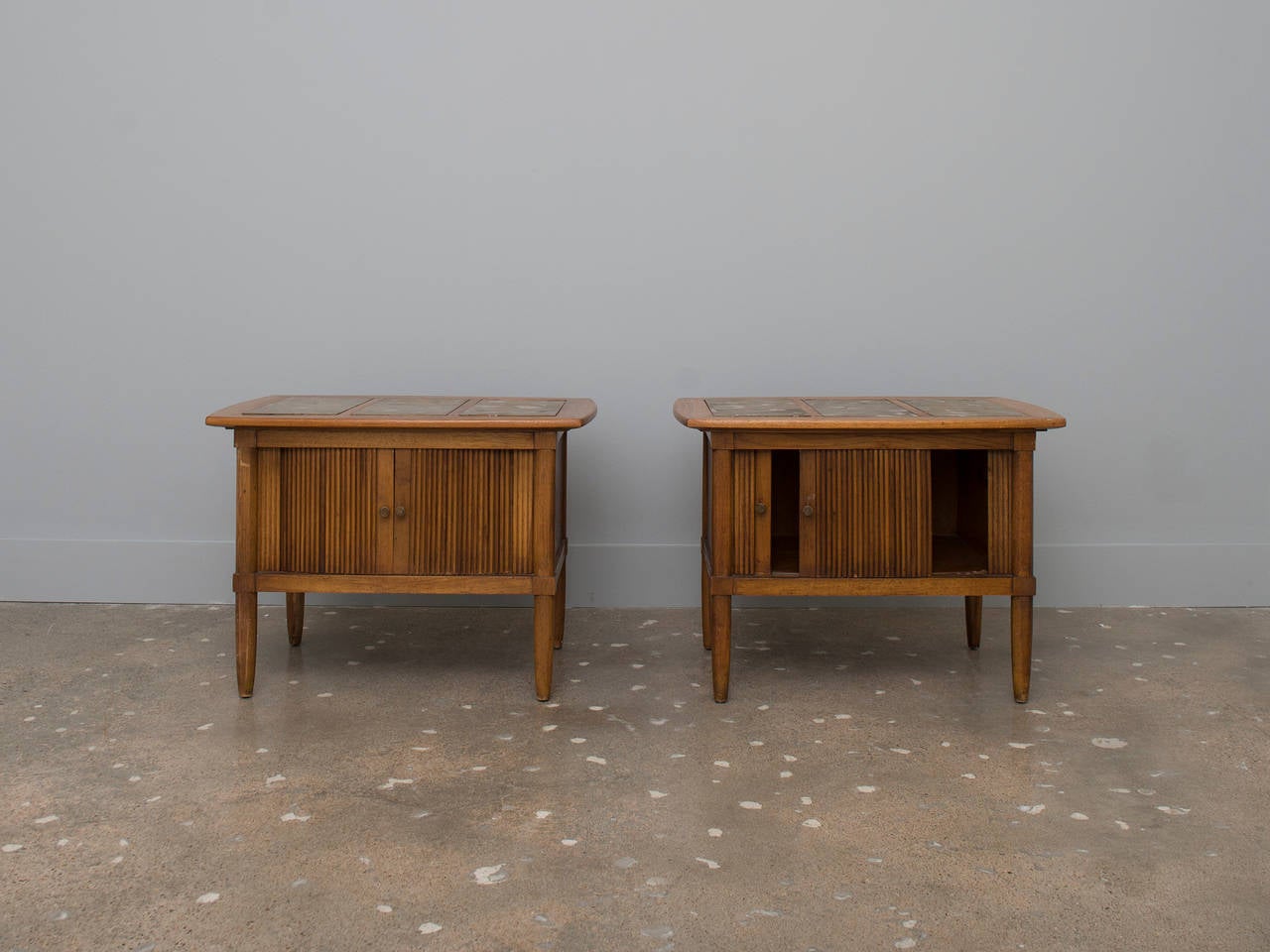 A pair of beautiful wood side tables with granite inlay design on top and tambour doors.