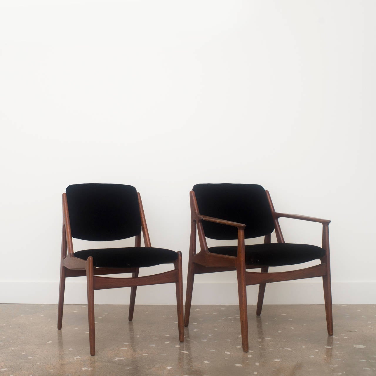 Set of six rosewood Ella dining chairs, including one armchair, with contoured, pivotal backrests. Upholstered seats and backs are in black mohair fabric.