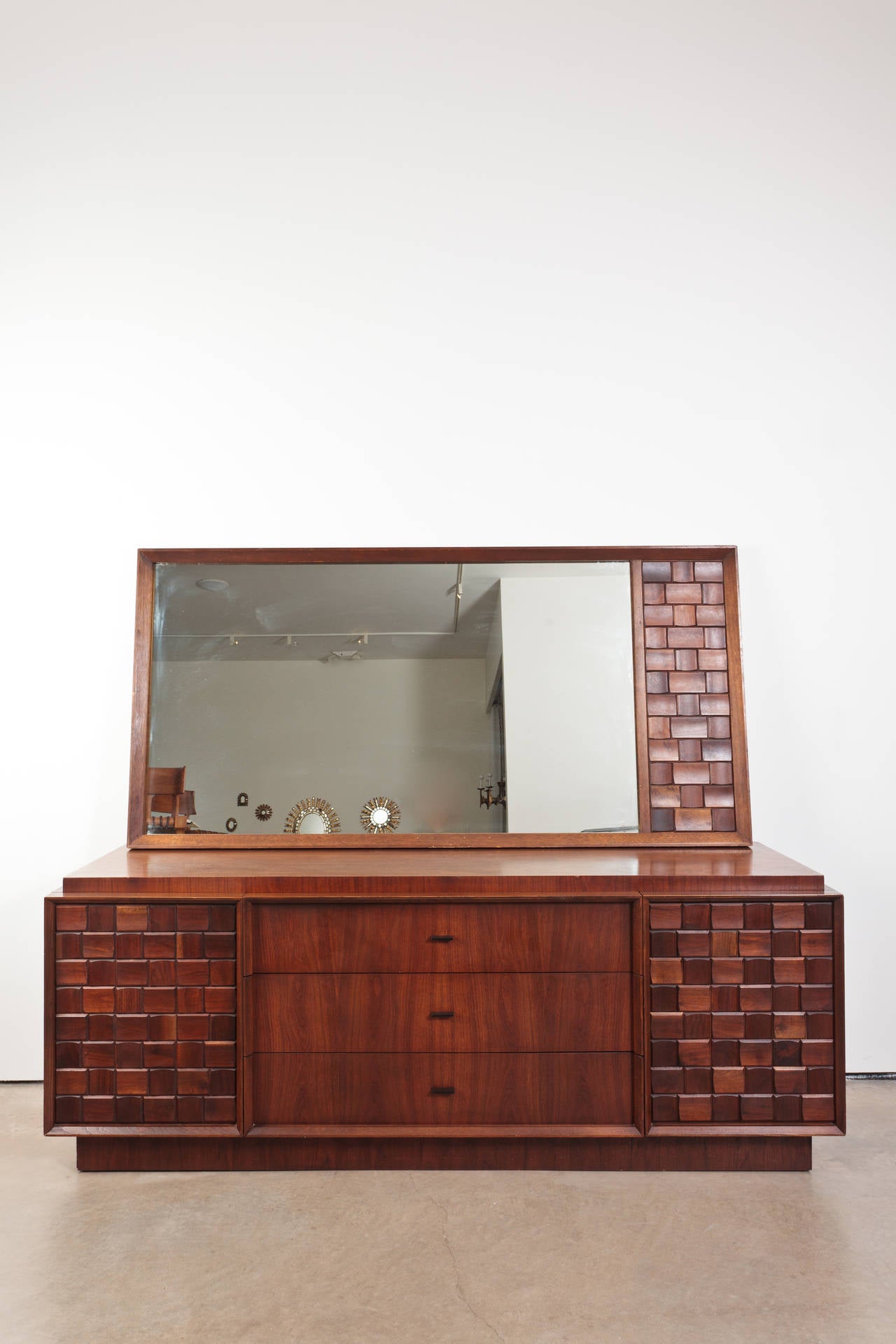 The detailing on this is exquisite. The dresser face has alternating vertical and horizontal wooden tiles providing a three dimensional look. Sturdy and handsome piece---difficult to find in this condition. Mirror not available.