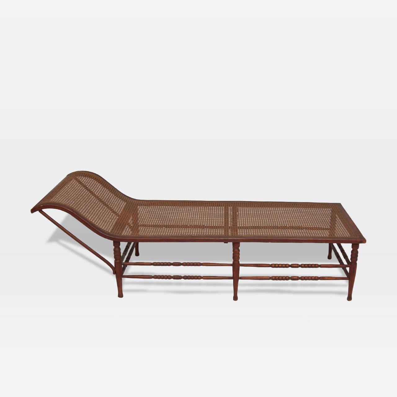 Dutch Colonial solid rosewood daybed with six turned legs and caned seat.