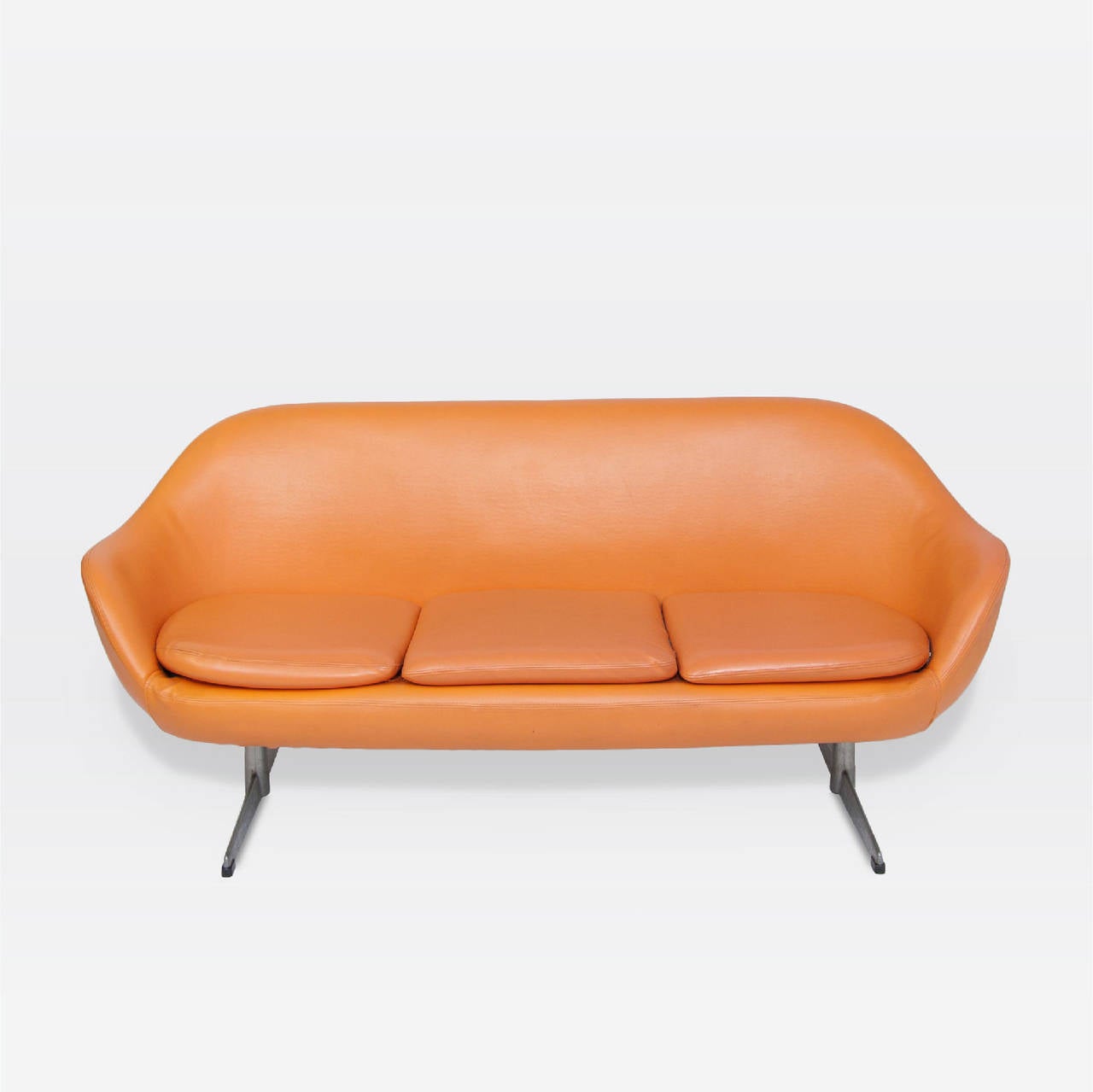 Roto three cushion orange vinyl upholstered sofa. Brushed aluminum legs.