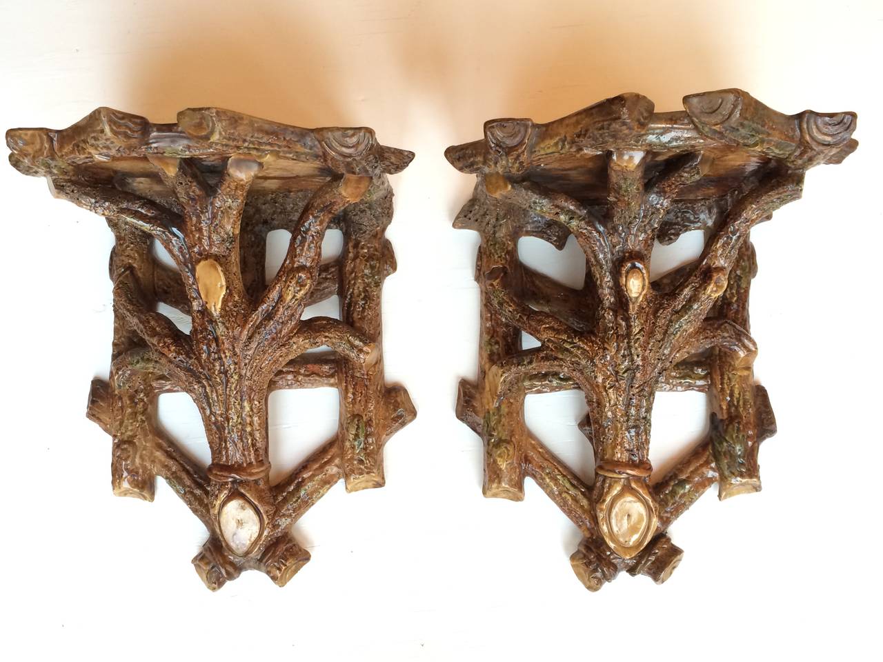 Pair of glazed ceramic branch form (faux bois) wall shelves in the balmoral/ majolica style, circa 1880.  The scale of these wall shelves is unusual as they are particularly large.

Provenance: Ex collection of Leo Lerman & Gray Foy.