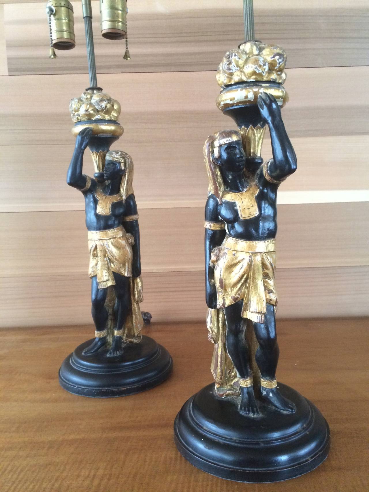 Pair of polychromed table lamps of Egyptian figures in the blackamoor style.
Possibly French or Venetian, circa 1870.

These lights were utilized as Mrs. Vreeland's personal bedside table lamps in her Manhattan Park Avenue apartment, designed by