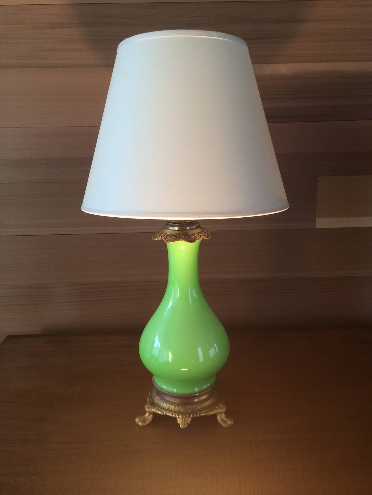 A 19th century lime green opaline glass table lamp mounted on a gilt bronze ormolu base. Lamp CAP later 20th century (when wired for electricity),
France, circa 1880. Shade not included. 