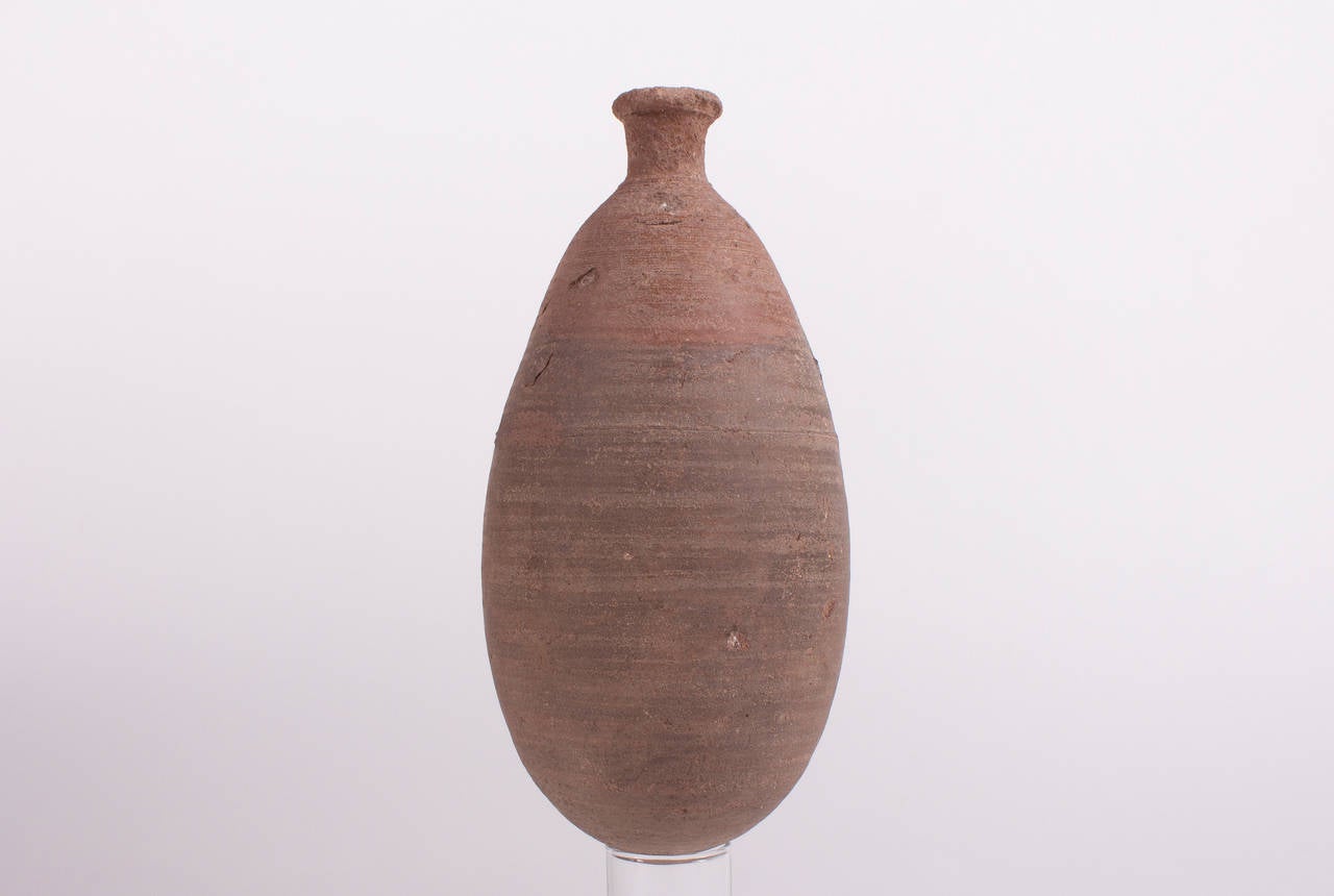 A rare,  about 5 thousand years old Sumerian storage Vessel in bottled form in reddish, ocherous, brown,  burnt Clay, Elliptical vessel with conical bottom , short , constricted neck with flared mouth. Syria , Euphrates area , Habuba Kabira , 2. / 3