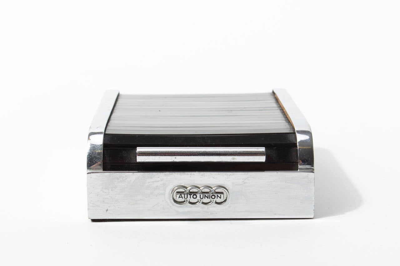 The presented rolltop dispenser was a merchandise gift designed and produced by Carl Auböck for Audi (Autounion) in the 1950s.

Made from the typical nickel plated brass and lacquered lid.
In very good vintage condition.

A similar is