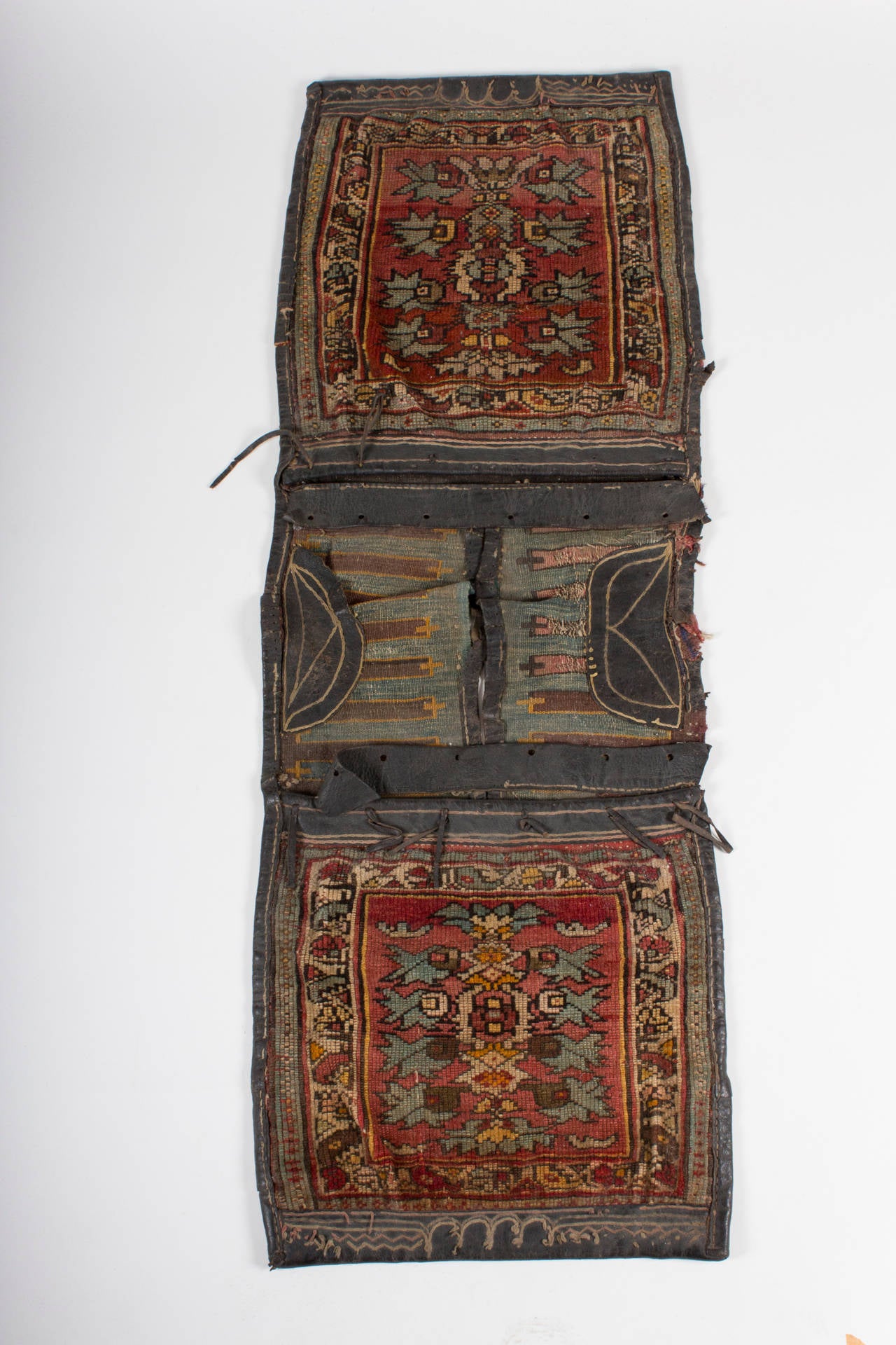 The presented Heybe, a complete and therefore very rare item from central Anatolia, ca. 1860. Made of fine wool, with original leather mounts, knotted side wings and a Kelim for each bags front and backside.

Please compare to similar Heybes in