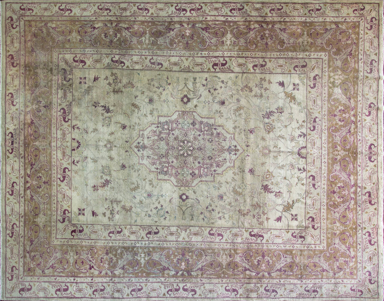 An antique Amritsar carpet that was woven in India around the turn of the 20th century. Characterized by beautifully precise line work as well as a charmingly muted pallet of pale pink and gold, this Amritsar carpet exemplifies some of the finest