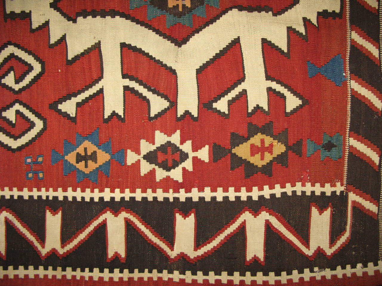 Antique Kilim long carpet, Kuba, late 19th century. An impressive design of serrated palmette medallions on a soft red field on this magnificent antique Kuba Kilim. The form of these palmettes recall the great classical carpets of the Caucasus, or