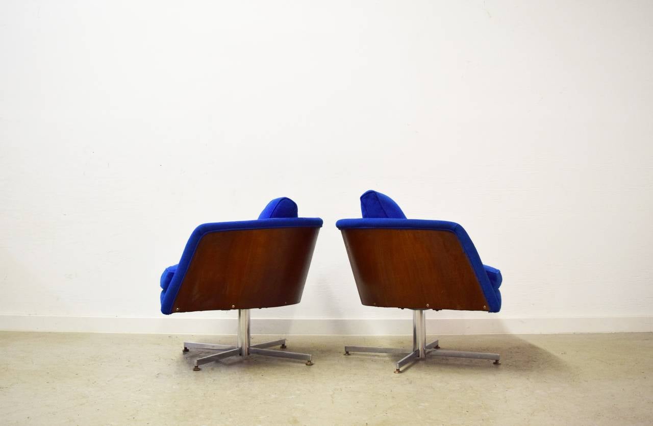 Pair of Milo Baughman Swivel Lounge Chairs. Chairs have curved walnut veneer backs. Chairs have original labels.
