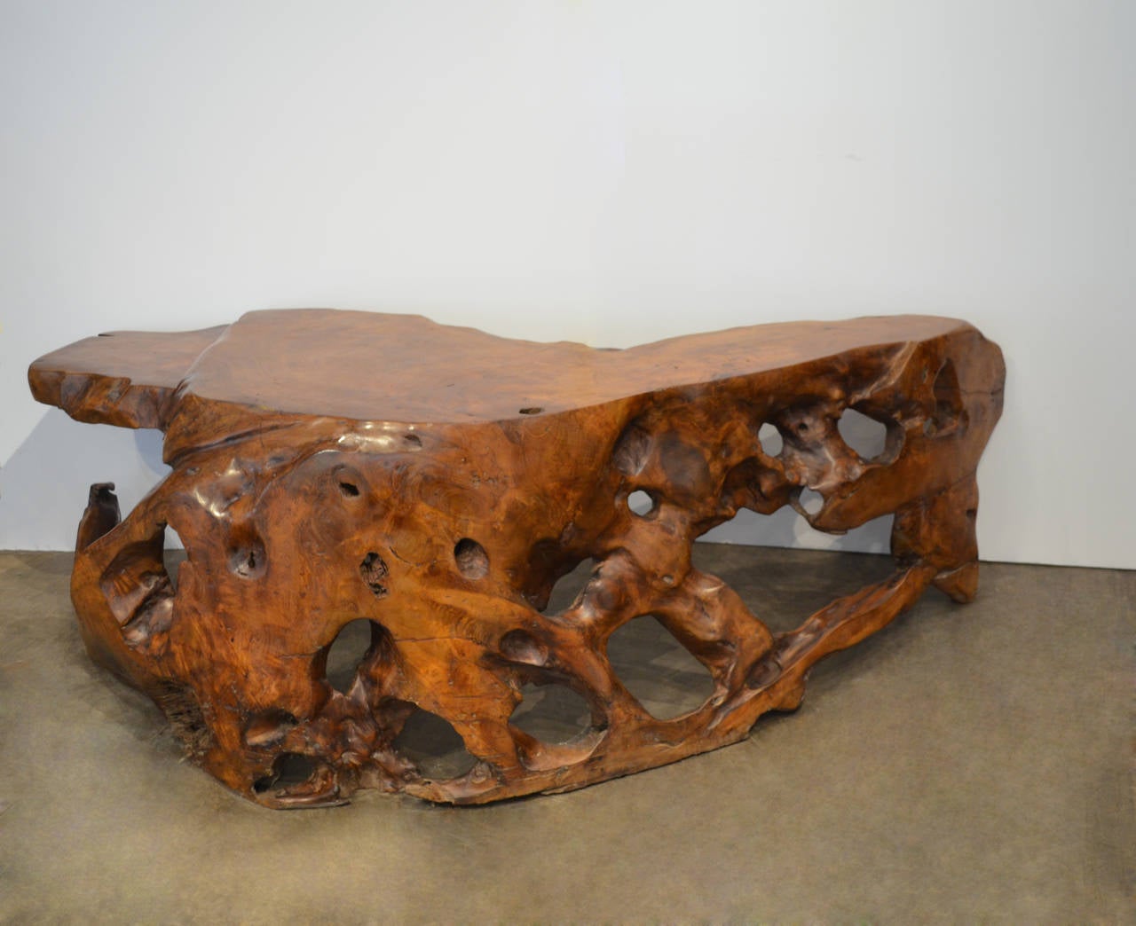 Stunning sculptural table carved from a single piece of teak wood from the root of a tree. Is also sturdy enough to be used as a sculptural bench.