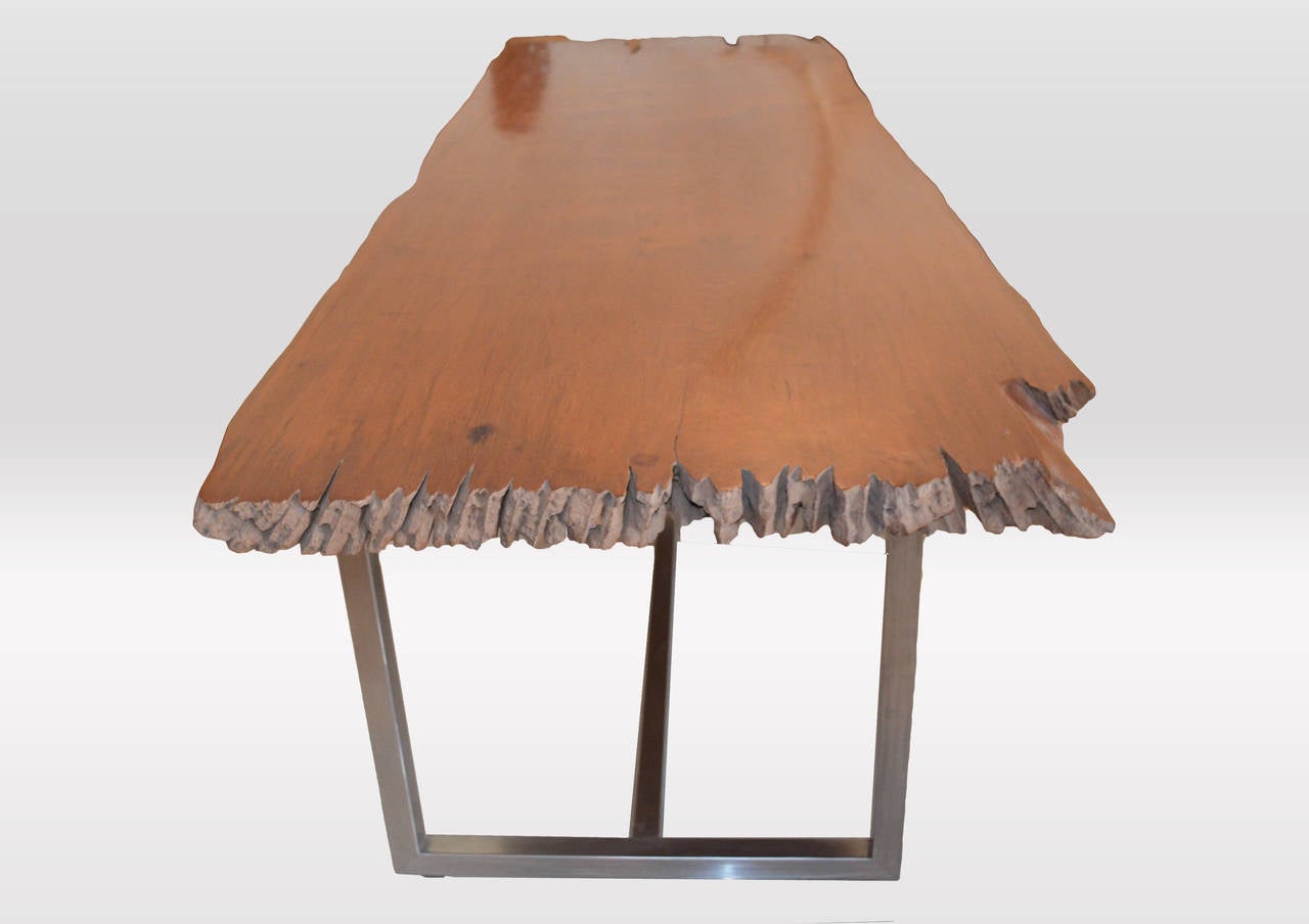 Impressive two inch single teak slab dining table with beautiful natural eroded ends. Set on a modern steel base.

Own an Andrianna Shamaris original.

Andrianna Shamaris. The Leader In Modern Organic Design™