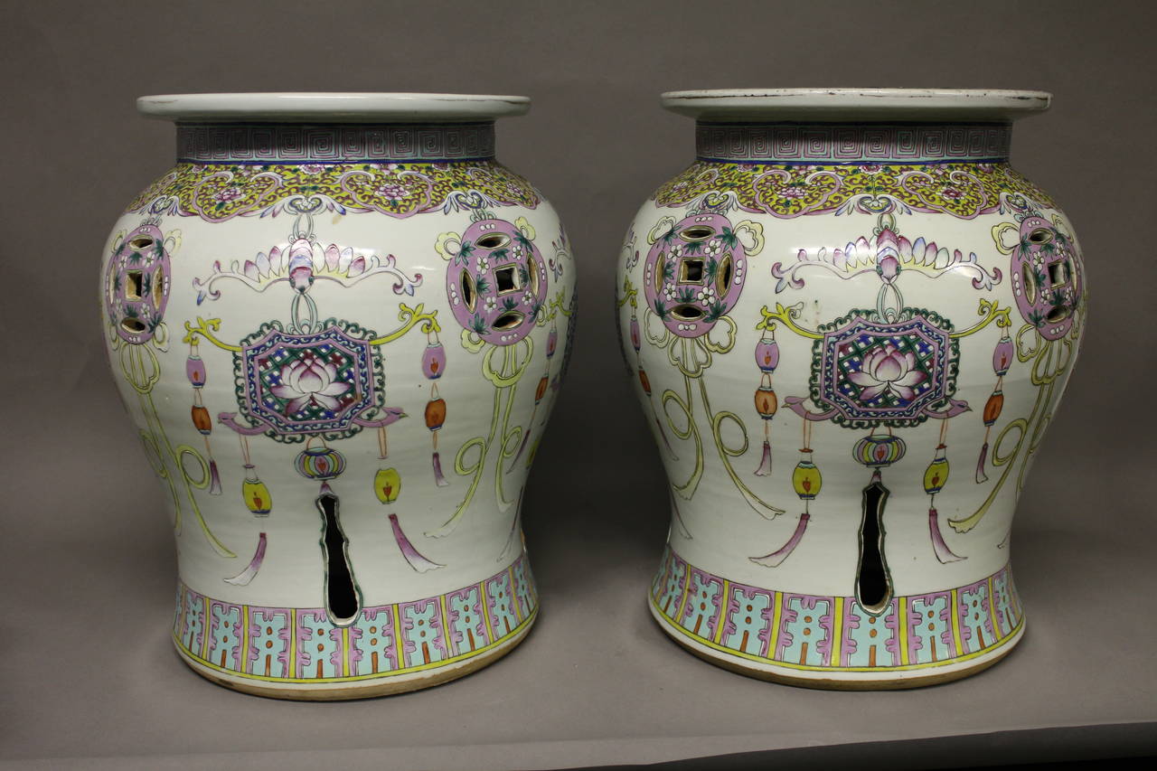A pair of Chinese famille rose garden seats decorated with a floral lantern design and pierced decoration.