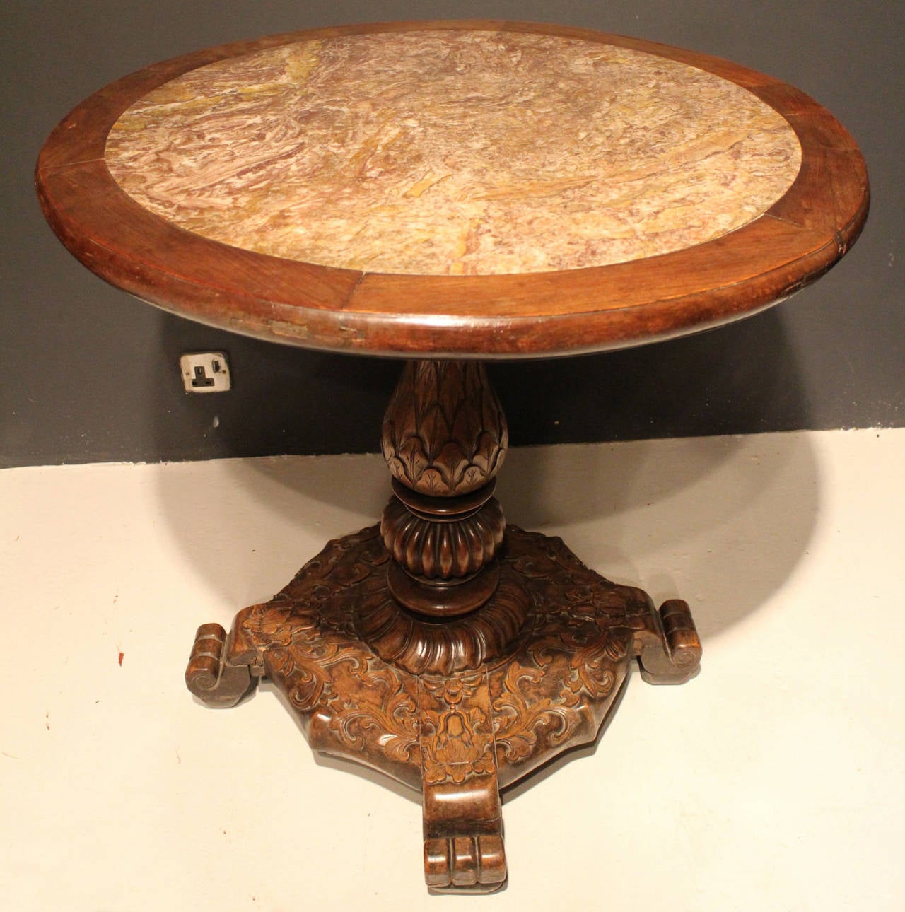 A medium sized Chinese marble-topped table on a carved wooden base.

