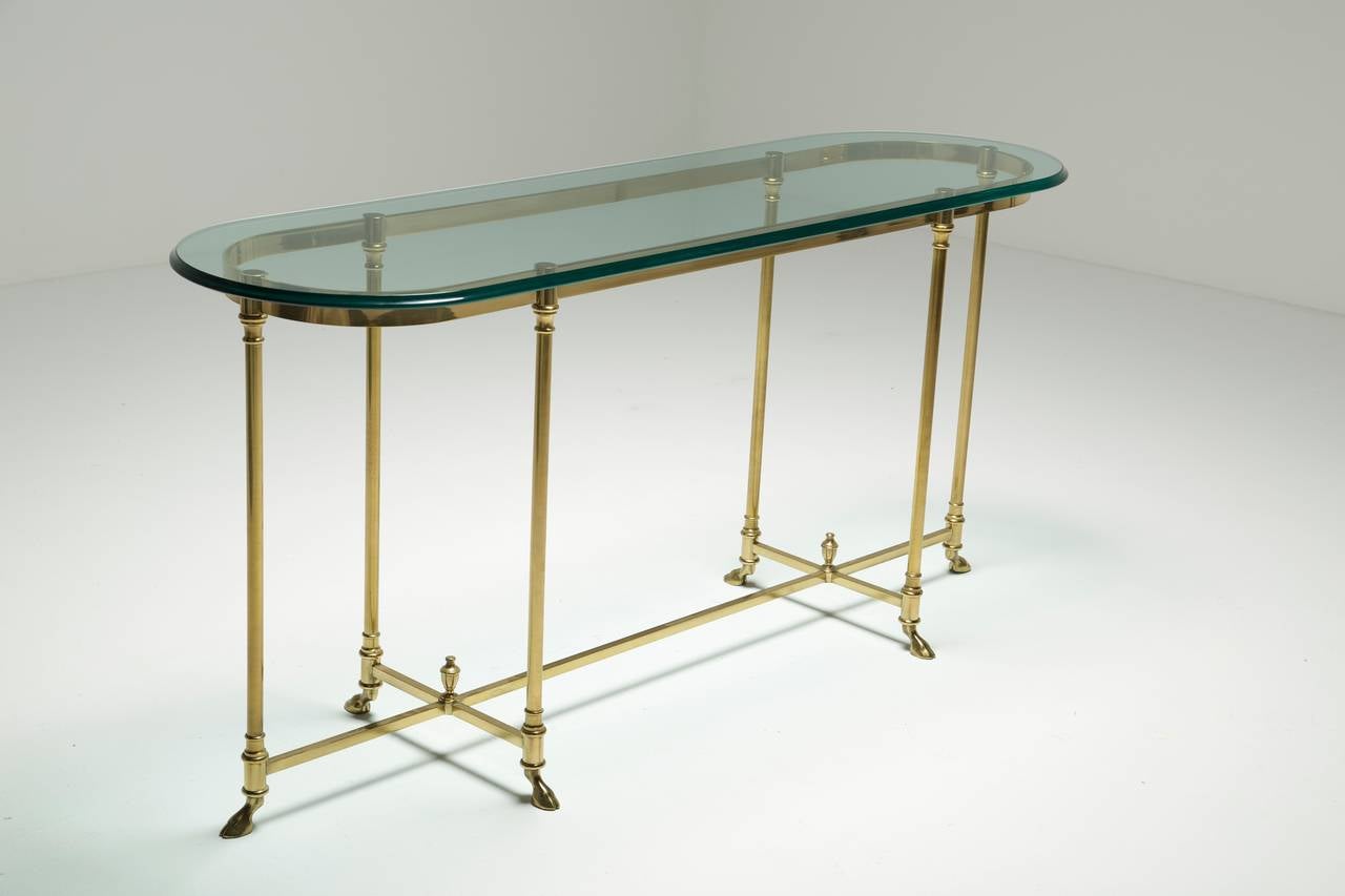 A Brass console table by Labarge. Beautiful custom glass top and lovely details like the hoof feet on the base. The table is in very good original condition. A very beautiful console table that would suit an entry hall or living room.