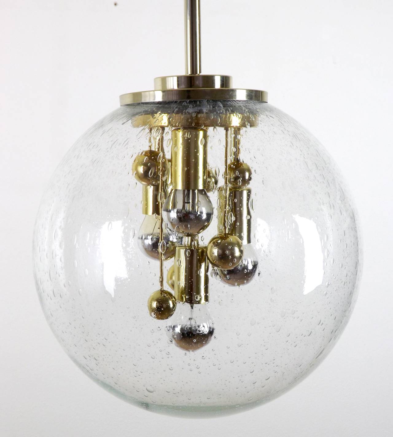 A fantastic pendant light chandelier by Doria Leuchten, Germany, manufactured in Mid-Century, circa 1970 (late 1960s or early 1970s).
An extra large hand blown glass globe with a brass fixture.
The lamp has four sockets for medium or standard screw