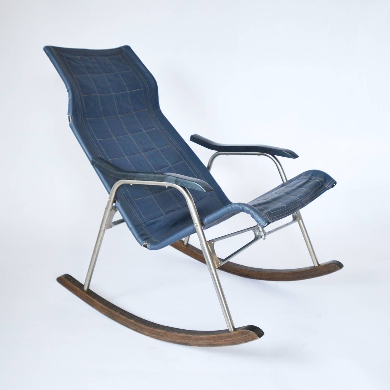 Rare folding rocking chair. It can be folded in the middle to a width of only 5.5 inch (14 cm). The seat height is 11.8-17.7 inch (30 - 45 cm). Nice mixture of materials: chrome, wood, blue synthetic leather.

Very good condition, only few wear of