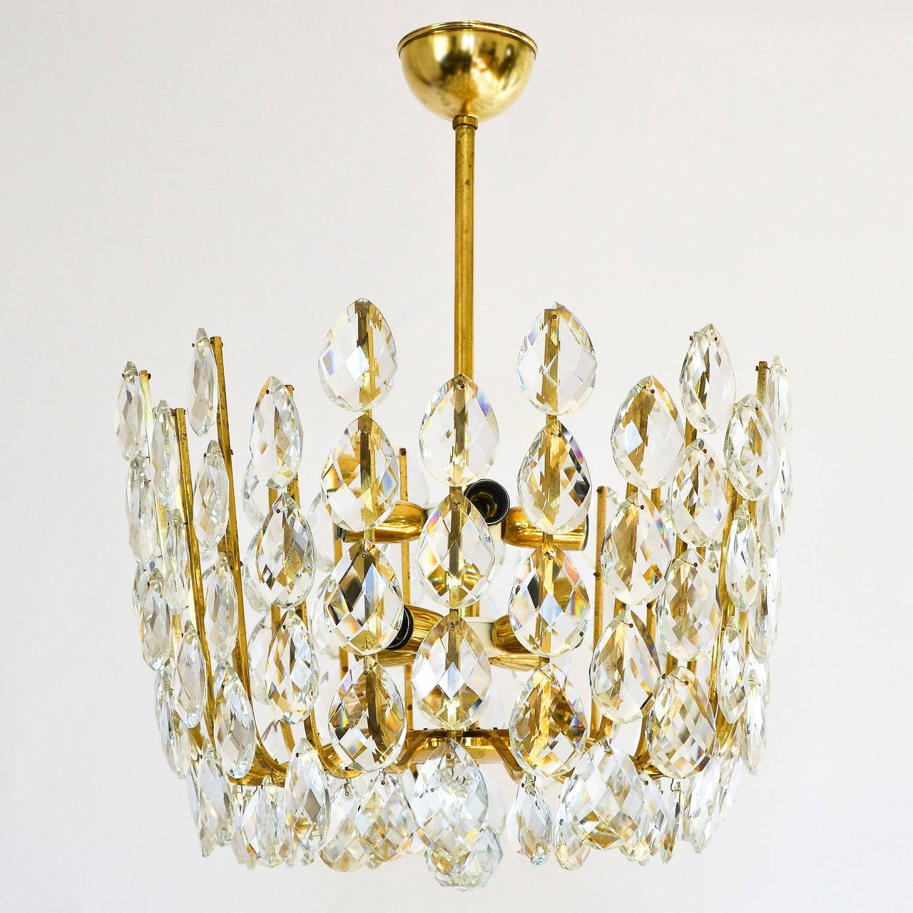 A beautiful and high quality Viennese basket chandelier manufactured in midcentury, circa 1960 (late 1950s or early 1960s). 
Attributed to Kalmar, Austria. 
It is made of brass and large crystal glasses. The lamp has eight sockets for small screw